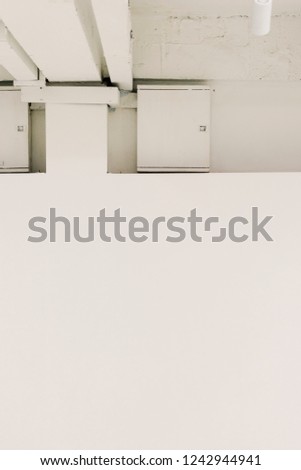 White ceiling and meter boxes inside of an art gallery