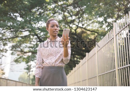 Upset black lady looking at her phone