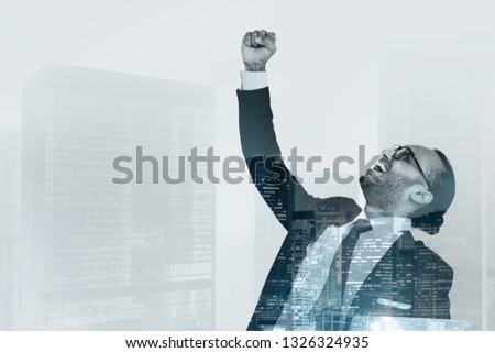 Successful businessman raising his hand in the air