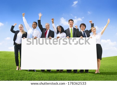 Business People Celebrating with Placard on Hill