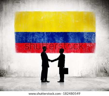 Two Businessmen Shaking Hands With Colombian Flag In Background