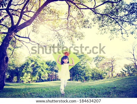 Cheerful Asian Child Playing With a Kite In a Park