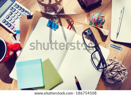 Messy Designer\'s Table with Blank Note and Tools