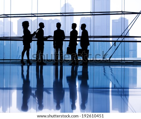Silhouettes of business people discussing in an office.