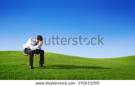 Depressed businessmen sitting outdoors.