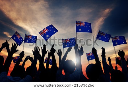 Group of People Waving Australian Flags in Back Lit