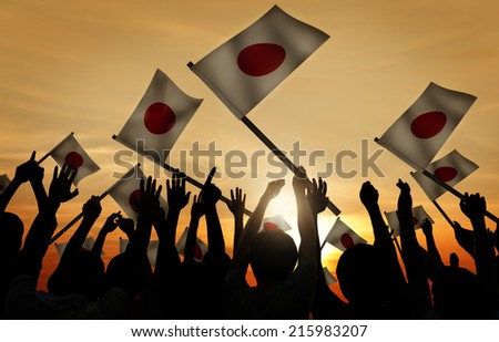 Group of People Waving Japanese Flags in Back Lit