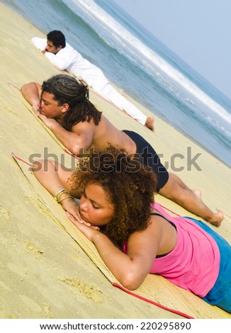 Yoga class by the beach lying face down.