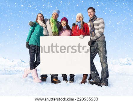 Group of people holding blank placard on snow covered mountain.