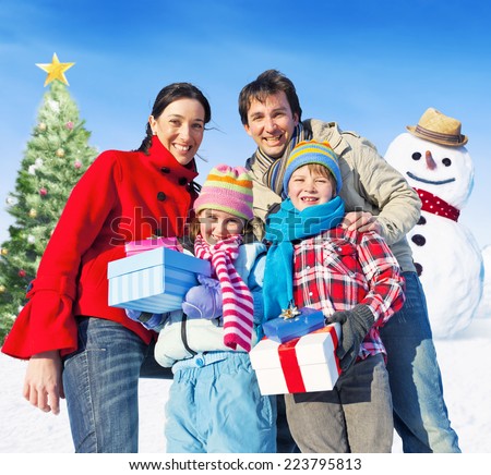 Family posing for camera having christmas tree and a snowman as a background.