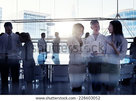 Silhouettes Of Multi-Ethnic Group Of Business People Working Together In A Board Room