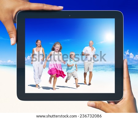 Family having fun on the beach with tablet pc frame.