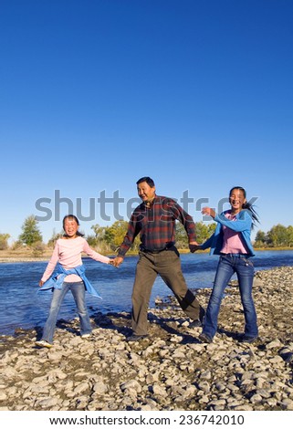 Mongolian family anjoy walking by the river.