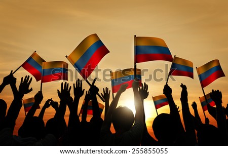 Group of People Waving Columbian Flags in Back Lit
