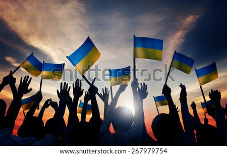 Group of People Waving Ukranian Flags in Back Lit