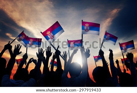 Group of People Waving Flag of Serbia in Back Lit