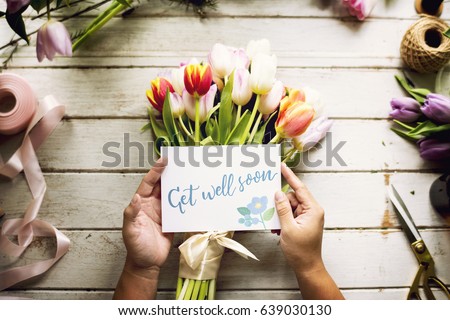 Hand Holding Show Get Well Soon Card with Tips Flowers Background