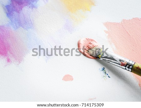 Paintbrush with color on a canvas painting