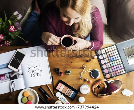 Woman enjoying a coffee break whilst testing make up products