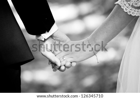 Young married couple holding hands on wedding day