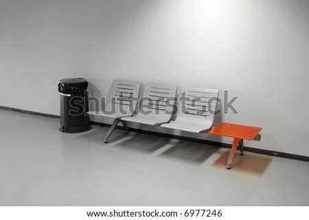 Waiting room - chairs, trash bin and an orange table