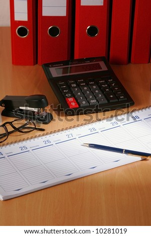Date book on desk with red files on background