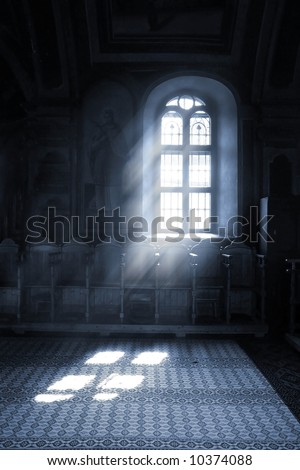 stock photo : Shafts of light stream through stained glass window inside a 