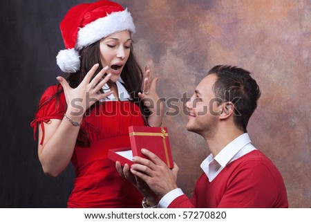 in love young couple with christmas clothes and surprising gift
