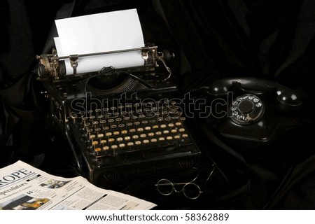Old fashioned, vintage photo of an old type writer with phone , glasses and newspaper