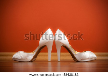 Pair of white female shoes on the floor