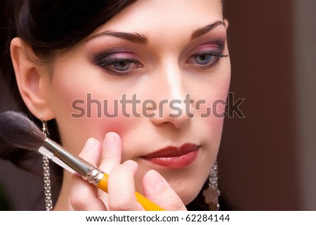 closeup brunette young lady bride get ready for the event by makeup artist