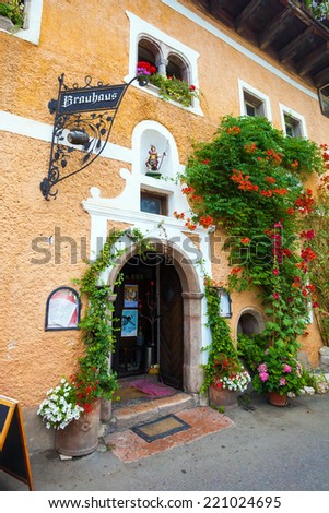Hallstatt, Austria - August 7, 2013: Typical guest house covered with flower plants in Hallstatt village, Austria