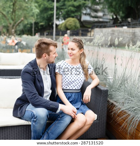 A young couple spends time on the couch in the outdoor cafe near the Baltic Sea