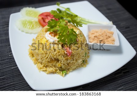 Baked rice with pineapple or Pineapple Fried Rice with Shrimp and dried shredded pork in white dish