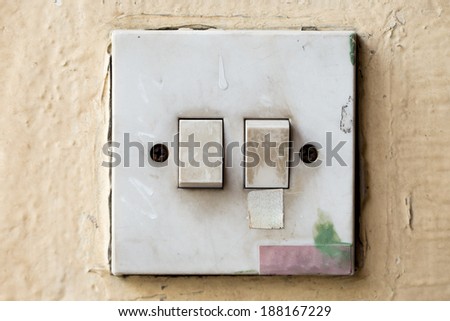 Old and dirty Light control switch on yellow background