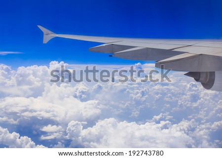 Wing of an airplane flying above the clouds. people looks at the sky from the window of the plane