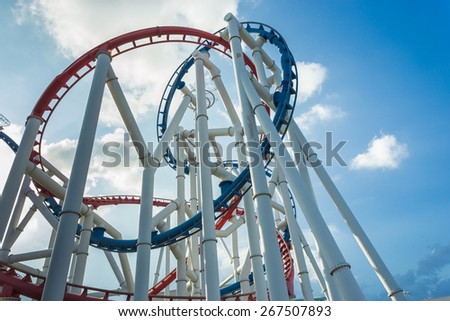 a roller coaster\'s loop with blue sky