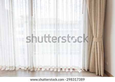 Light shines through white curtains in room