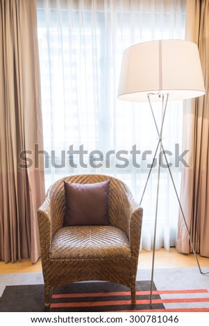 Light shines through white curtains in room with weave Rattan stick chairs