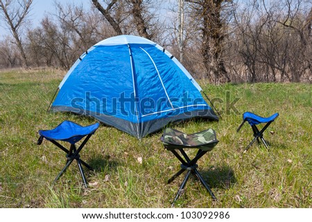tourist tent an chairs in spring forest