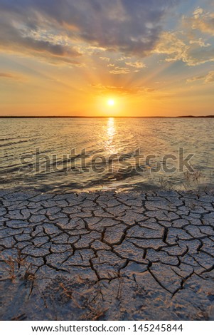 cracked earth seacoast on sunset background