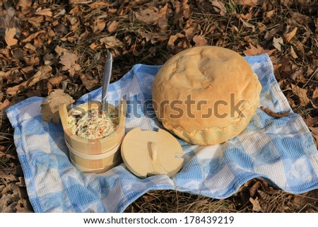 bread and wooden dish on blue cloth in park