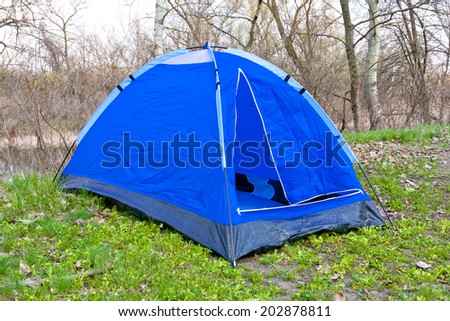 Blue tourist tent in forest at spring time