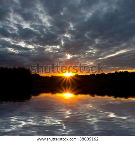 Nice sunset and lead clouds with water reflection