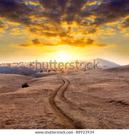 Mountain road on sunset background
