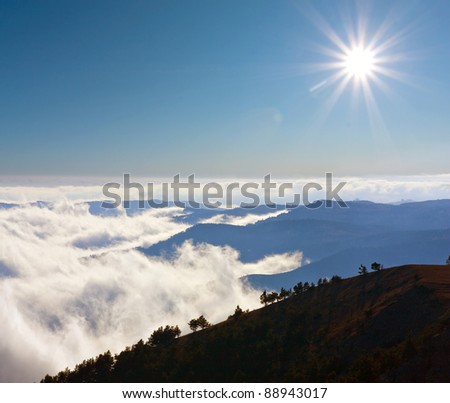 Mountain\'s scene with sun over clouds on mountains range