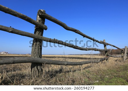 Wooden fence near border of agriculture field