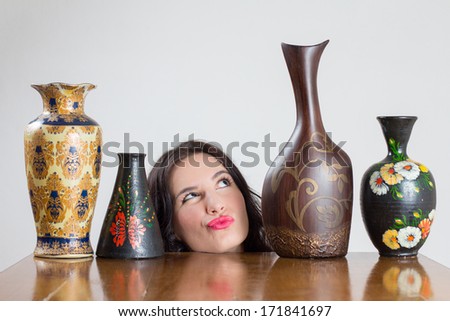 Girl head with vases on table looking at the highest vase