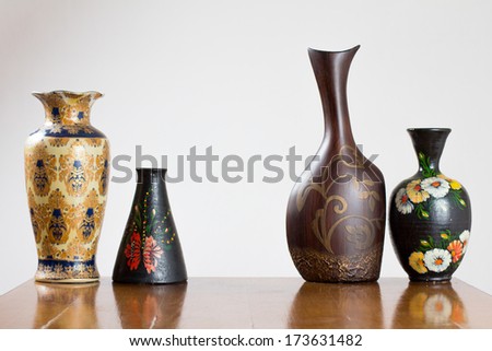 Four different vases on a table, with empty space between