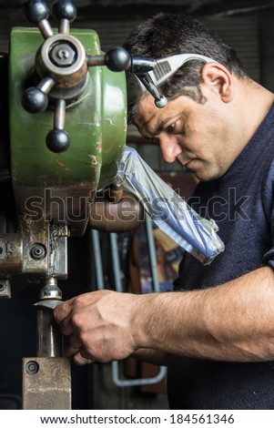 Man working with a metal pressing machine